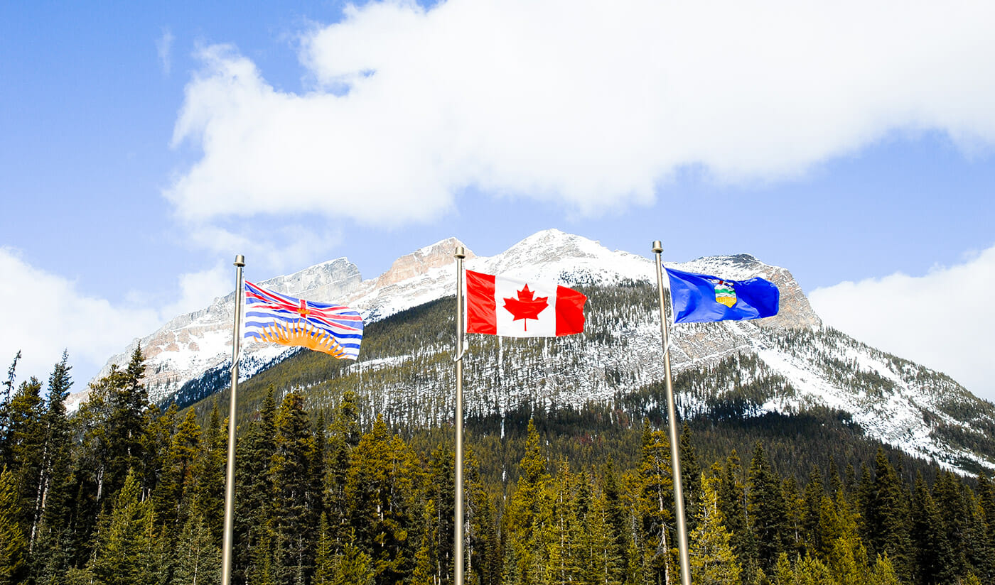 Flags of Canada and British Columbia with a mountain in the back