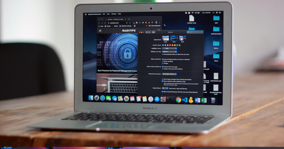 Open MacBook Air displaying system preferences and a cybersecurity webpage, placed on a wooden desk.
